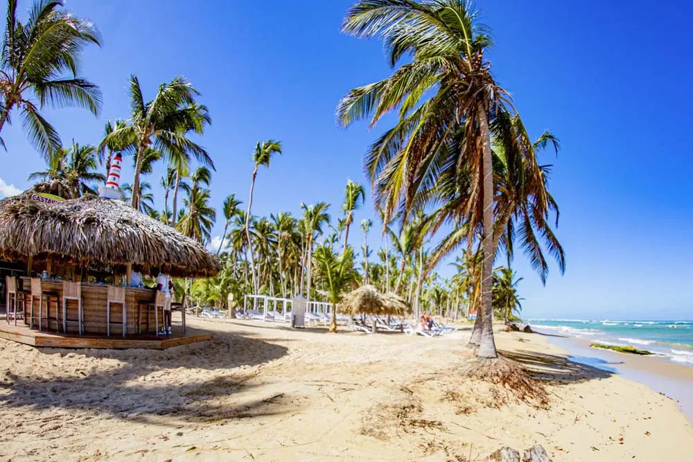 A view of the sunny beach and bar at Castaway's Restaurant at Playa Palmera